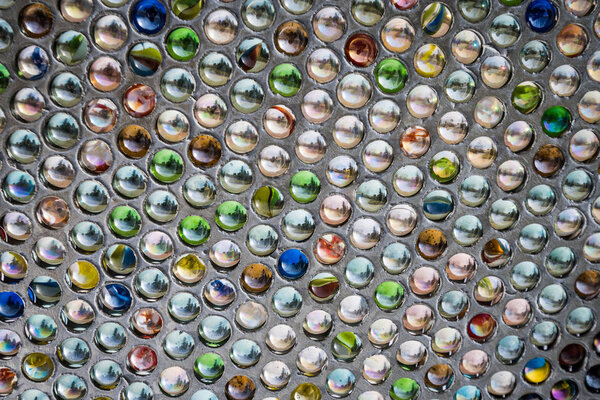 Beautiful abstract background image of colorful vintage glass marbles in a metal display case with use of soft focus, blurring out the background & foreground around the main focus point