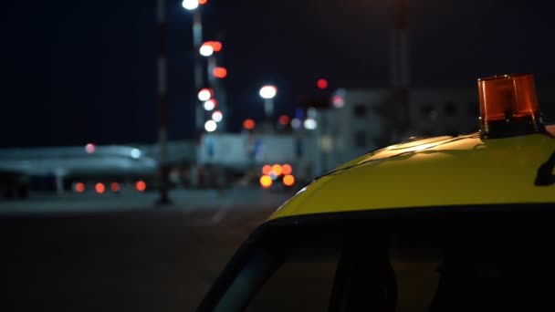 闪光灯汽车护航飞机在夜间机场的站台上 — 图库视频影像