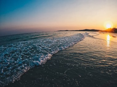 Konsept tasarım için gün batımı sahnesiyle sahilde dalga sıçraması.