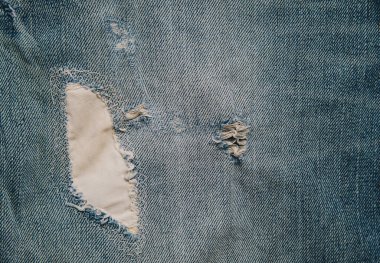 Tasarım konsepti için mavi kot pantolon deseninde yırtılmış yama kapatıldı