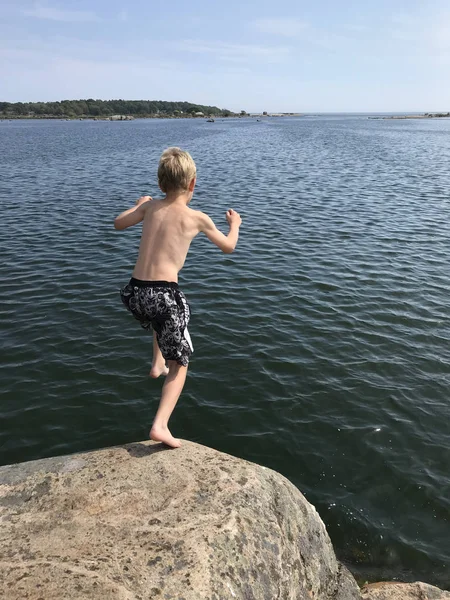 Niño Saltando Desde Acantilado Océano —  Fotos de Stock