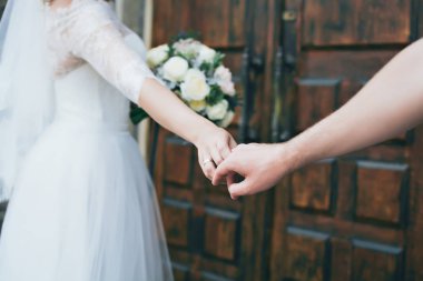 Damat gelinin elini tutar