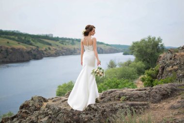  Bir buket çiçekli gelinlik içinde güzel bir gelin.