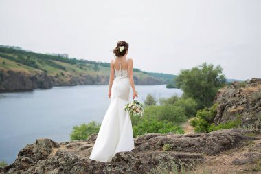  Bir buket çiçekli gelinlik içinde güzel bir gelin.