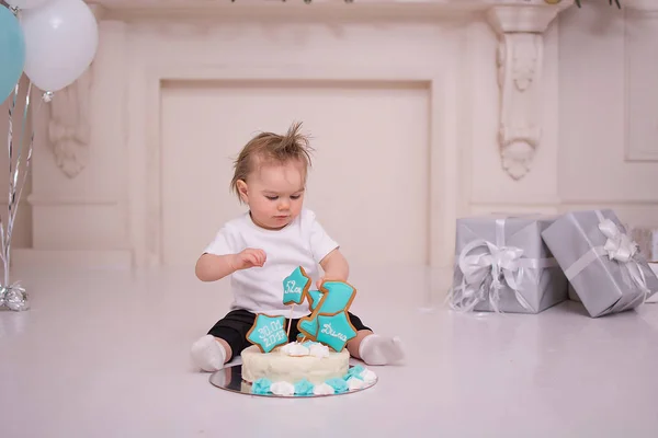 The baby is eating the first birthday cake
