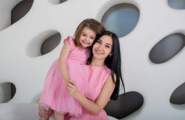 Güzel anne ve kız pembe elbiseler giyiyorlar. 