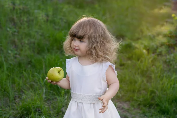 Lilla Vackra Flicka Vit Klänning Som Äta Ett Grönt Äpple — Stockfoto