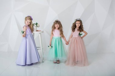 Peş peşe üç kız. Banyodaki bir grup insan. Güzel kızlar oynar ve eğlenir. Zarif elbiseli çocuklar. Beyaz arkaplandaki çocuklar