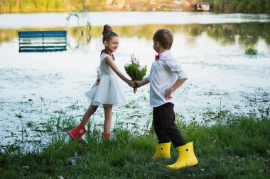 Çocuk doğada oyun. Çocuk kız çiçek verir. Doğa çocuk. Arkadaşlar
