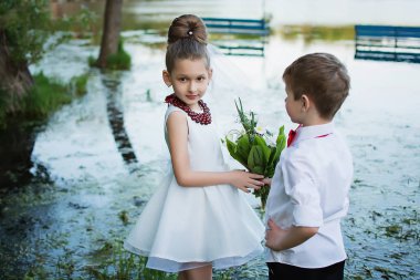 Çocuk doğada oyun. Çocuk kız çiçek verir. Doğa çocuk. Arkadaşlar