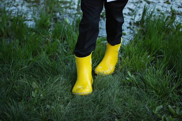 Rubber boots. Legs in rubber boots stand in a puddle