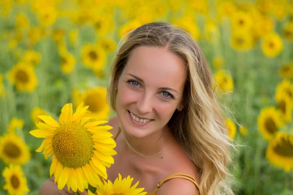 Happy woman with sunflowers. The girl in the fields of a sunflower