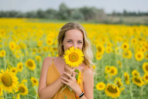 Happy woman with sunflowers. The girl in the fields of a sunflower