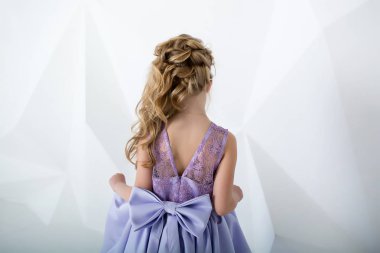 Güzel kız uzun elbise gülümsüyor. Beyaz Oda bir çocuk. Kız zarif elbise