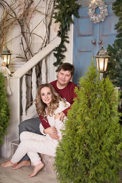 クリスマスツリーの前の若いカップルは — ストック写真