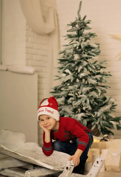 Liten Gutt Med Santa Hatt Nær Juletreet – stockfoto