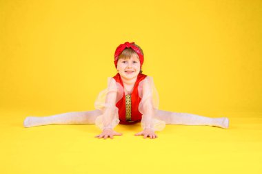 Çocuk sınıf gösterir ve bölmeleri üzerinde oturur. Sarı arka plan. Stilize kırmızı elbiseli uzun saçlı kız