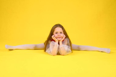 Çocuk sınıf gösterir ve bölmeleri üzerinde oturur. Sarı arka plan. Stilize kırmızı elbiseli uzun saçlı kız