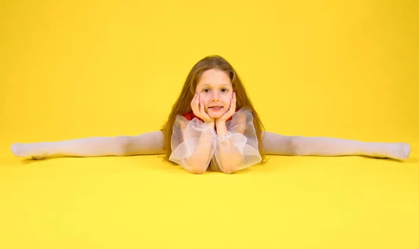 Çocuk sınıf gösterir ve bölmeleri üzerinde oturur. Sarı arka plan. Stilize kırmızı elbiseli uzun saçlı kız