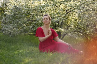 Elinde bir buket çiçekle genç bir kadın. Parktaki genç bir kadının portresi.