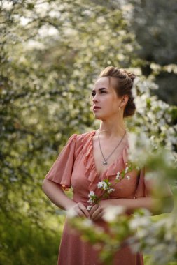 Parktaki çiçekli genç kadın.