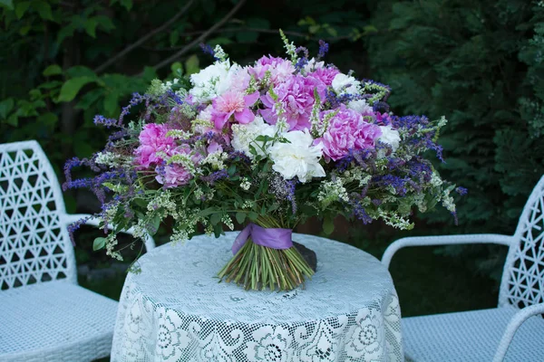 A bouquet of flowers is on the table. Flower arrangement of pink and wild flowers.