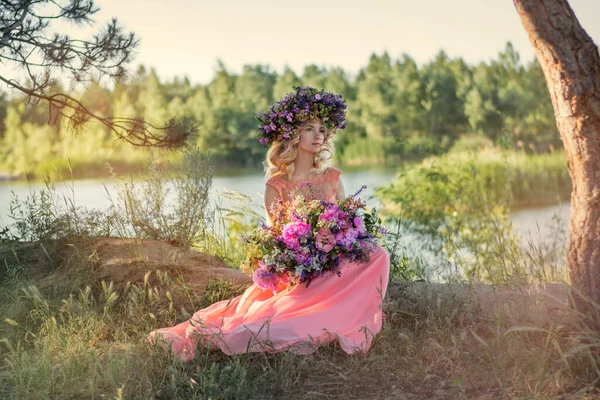Beautiful young woman at sunset. Girl in a wreath of flowers. Beautiful girl