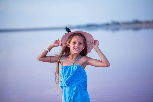 해변에서 모자쓴 노을에 분홍색 호수에 아름다운 어린이 — 스톡 사진