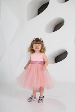 Pembe elbiseli küçük kız. Banyodaki genç kadın. Uzun elbiseli güzel kız gülümsüyor. Beyaz bir odada bir çocuk. Kızda şık bir elbise var.