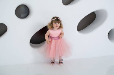 Pembe elbiseli küçük kız. Banyodaki genç kadın. Uzun elbiseli güzel kız gülümsüyor. Beyaz bir odada bir çocuk. Kızda şık bir elbise var.