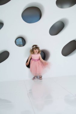 Pembe elbiseli küçük kız. Banyodaki genç kadın. Uzun elbiseli güzel kız gülümsüyor. Beyaz bir odada bir çocuk. Kızda şık bir elbise var.