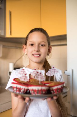 Mutfakta elinde mutlu noel kekleri olan bir kız.