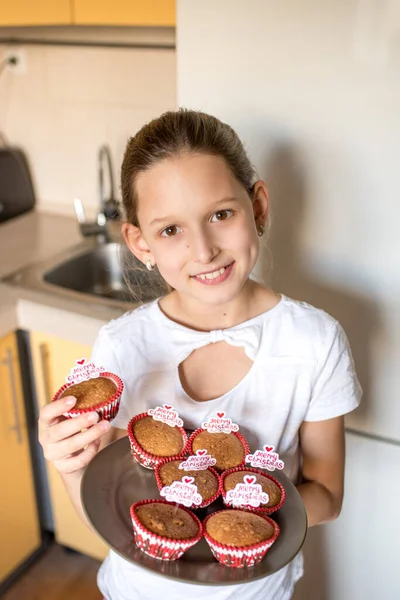 女の子保持トレイともに陽気なクリスマスカップケーキでキッチン — ストック写真