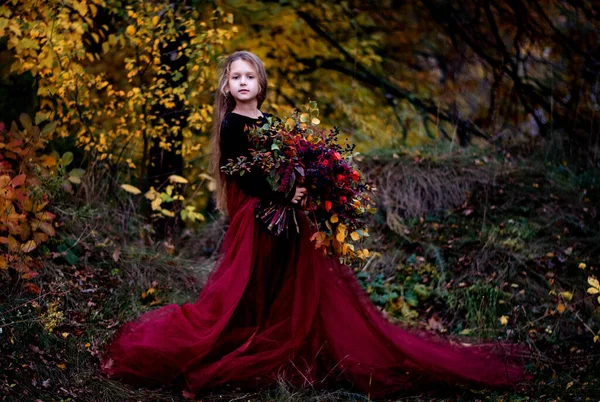 花を持つ少女の肖像画です 秋の公園に長い髪の美しい女の子 — ストック写真