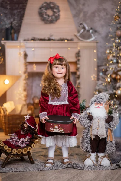 크리스마스 근처빨간 드레스를 인형을 크리스마스 놀이를 아이는 미소를 짓습니다 머리가 — 스톡 사진