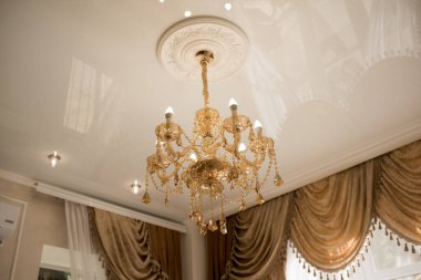 Yemek odasının tavanında kristal avize lambası. Görüntüyü lüks bir tonda ayarlıyor. Dekoratif zarif ve çağdaş iç mekan kavramı..