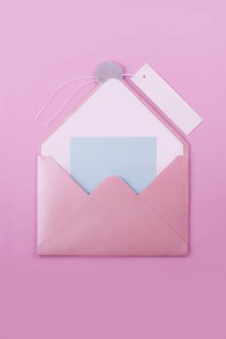 Pembe açık zarf harfli bir mum mühür ve bir ışık mor arka plan üzerinde kayıt için bir kağıt etiket. Herhangi bir ileti, örneğin romantik yazabilirsiniz bir mavi Not etiket ile gömülü olduğu.