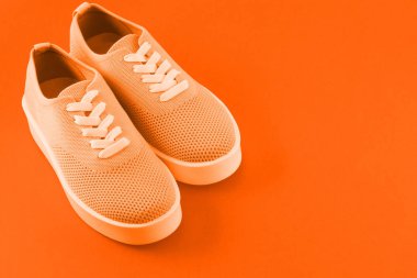 Yazıt için yer bıraktığı parlak turuncu arka plan üzerinde parlak turuncu spor ayakkabı.