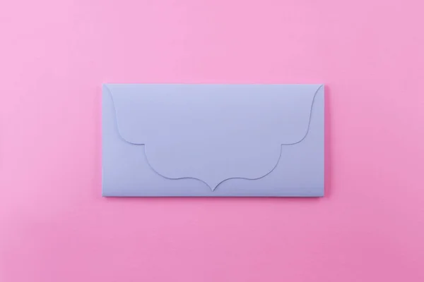 青い封筒はパステル ピンクの背景の文字です 封筒が閉じられ 中身を推測することができます — ストック写真