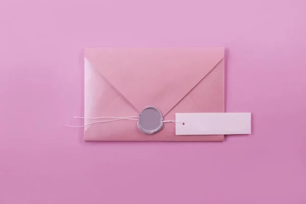 ワックス シールと光紫色の背景に署名の紙タグ ピンク封筒手紙 — ストック写真