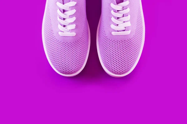 Light purple sneakers layout on a bright violet background with a place for an inscription.