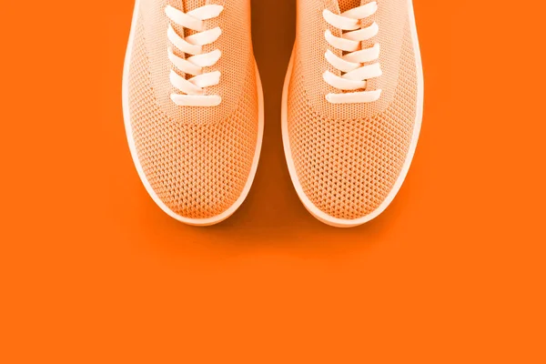 明亮的橙色运动鞋在橙色的背景与一个地方为题字 — 图库照片