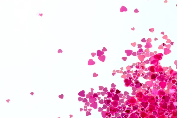 Pink sequins on a pink pastel background with confetti as asterisks.