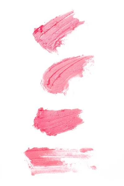 Bright beige smear of lipstick in the form of a group of diagonal strokes isolated on a white background.