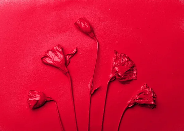 塗料の滴と赤い紙の背景に赤いエウストマの花. — ストック写真