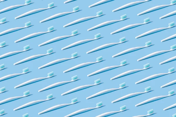 青い紙の背景に青い毛の白い歯ブラシ — ストック写真