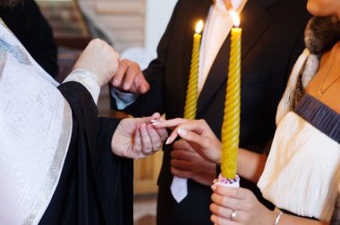 Rahip, gelin ve damada nikah töreninde yüzük takar.