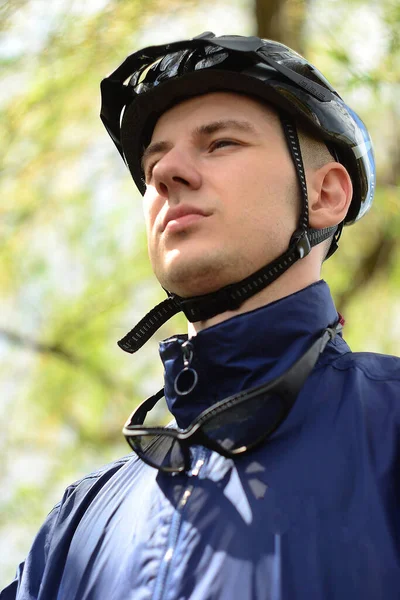 Kasklı, bisikletli bir gencin portresi.