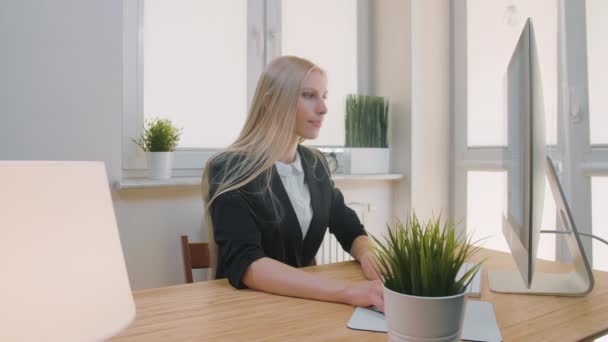 Verontrustende vrouw op het werk. Blond triest vrouwtje in elegante kleren knijpen hoofd na mislukking of slecht nieuws zittend in licht kantoor aan het bureau met computer. — Stockvideo