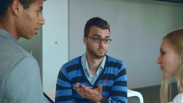 Männer und Frauen unterschiedlicher Rassen arbeiten an Berichten. Gruppe unterschiedlicher Frauen und Männer mit Tablet im modernen Bürosaal, die mit Dokumenten und Statistiken arbeiten. — Stockvideo